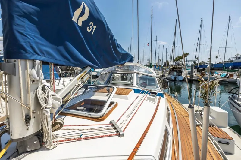 Roniin Yacht Photos Pics 2003 Hallberg-Rassy HR31 sailboat docked in marina, featuring teak deck and blue sail cover.