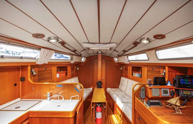 Roniin Yacht Photos Pics Interior of 2003 Hallberg-Rassy HR31 yacht, featuring wood finish, seating, and navigation equipment.