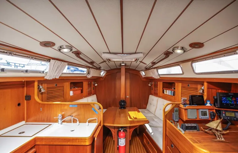 Roniin Yacht Photos Pics Interior of 2003 Hallberg-Rassy HR31 yacht, featuring wood finish, seating, and navigation equipment.