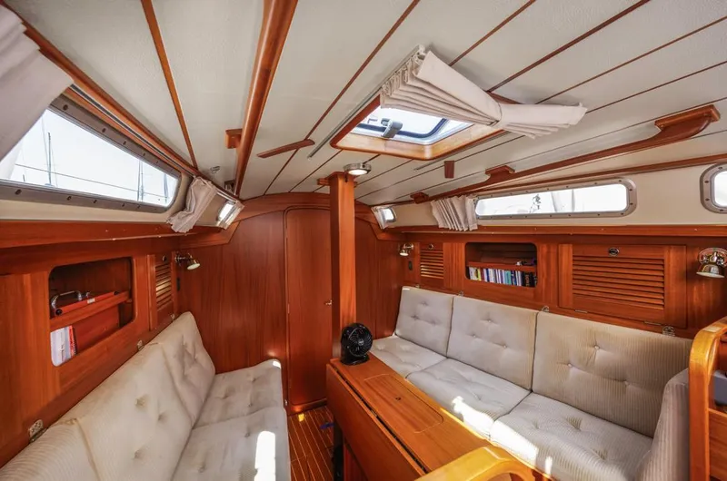 Roniin Yacht Photos Pics Interior of 2003 Hallberg-Rassy HR31 yacht, featuring wooden paneling and comfortable seating.