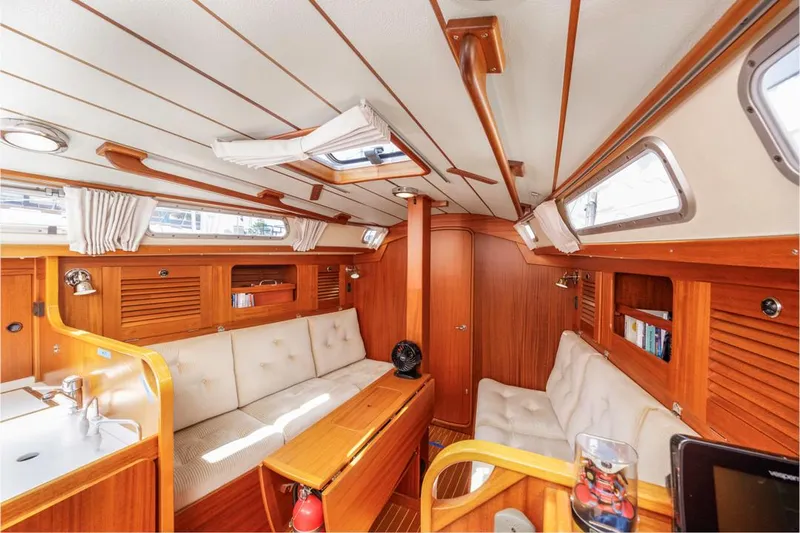 Roniin Yacht Photos Pics Interior of 2003 Hallberg-Rassy HR31 yacht with wooden finish and cozy seating area.