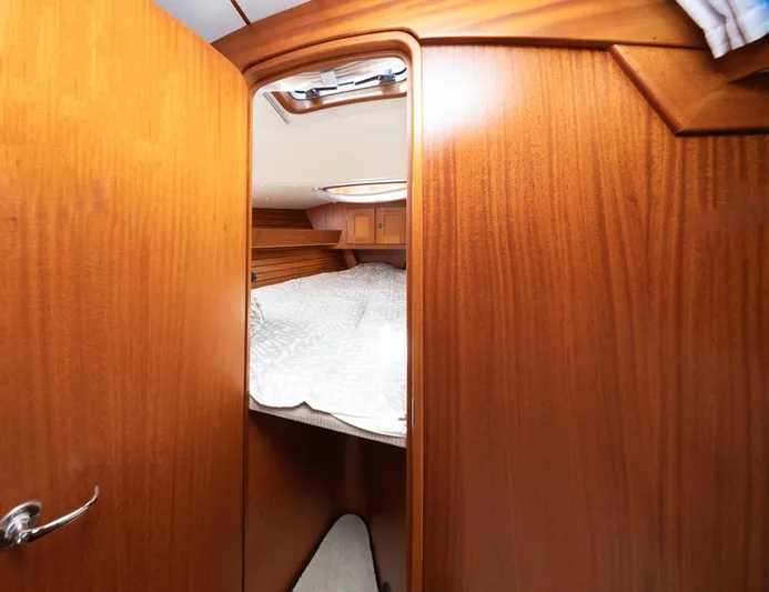 Roniin Yacht Photos Pics Interior cabin of 2003 Hallberg-Rassy HR31 sailboat with wooden finish and cozy bed.