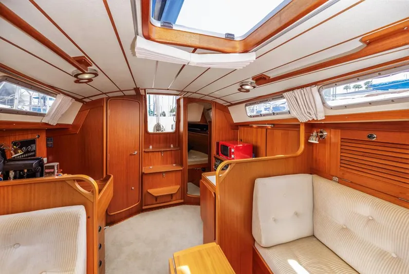 Roniin Yacht Photos Pics Interior of 2003 Hallberg-Rassy HR31 yacht, featuring wood paneling and cozy seating.