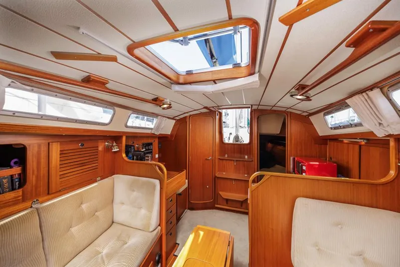 Roniin Yacht Photos Pics Interior of a 2003 Hallberg-Rassy HR31 sailboat, featuring wood paneling and comfortable seating.