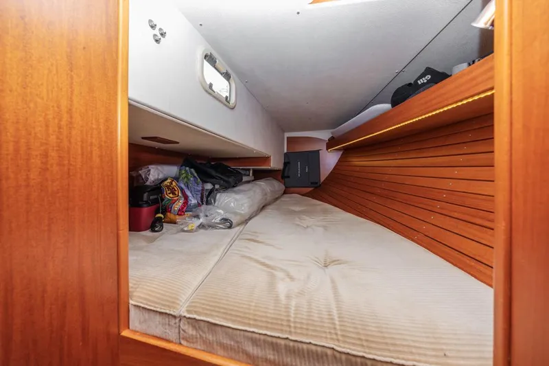 Roniin Yacht Photos Pics Cozy cabin interior of 2003 Hallberg-Rassy HR31 sailboat with wooden paneling and storage.