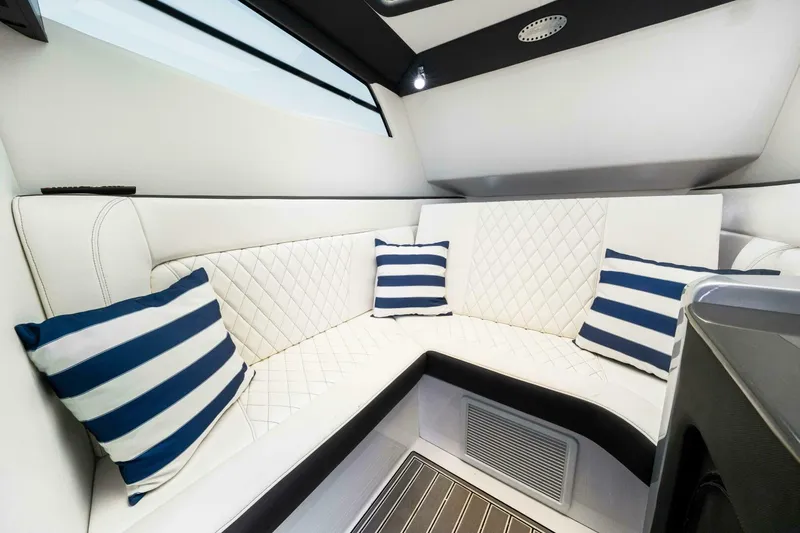 Rod's Jewel Yacht Photos Pics Luxurious interior of 2017 Nor-Tech 450SS boat with white seating and striped pillows.