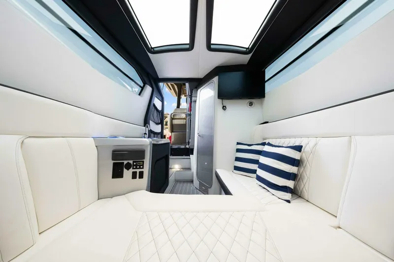 Rod's Jewel Yacht Photos Pics Luxurious interior of 2017 Nor-Tech 450SS boat with white seating and striped pillows.
