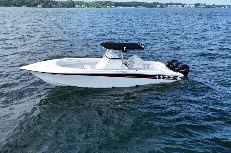  Yacht Photos Pics 2005 Fountain 34 Sportfish CC Open Bow boat on calm water, featuring triple Mercury engines.