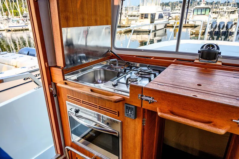  Yacht Photos Pics Compact kitchen area on a 2019 Targa 35 boat, featuring a stove and sink.