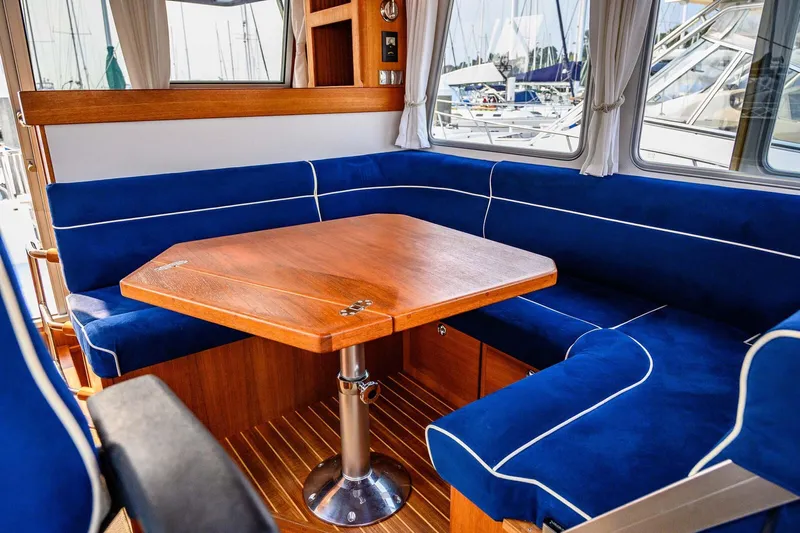  Yacht Photos Pics Interior of 2019 Targa 35 boat with blue cushioned seating and wooden table.