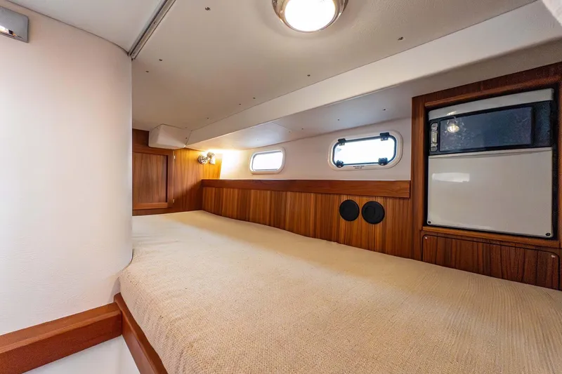  Yacht Photos Pics 2019 Targa 35 cabin interior with wood paneling and cozy bed.