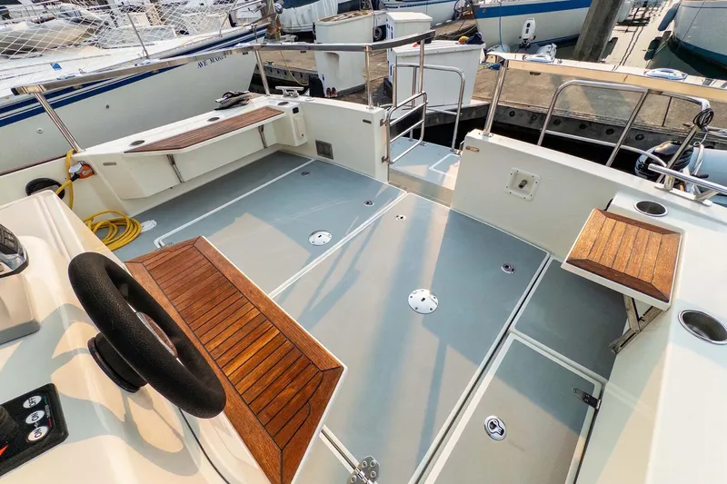  Yacht Photos Pics 2019 Targa 35 boat deck with wooden seating and steering wheel, docked at marina.