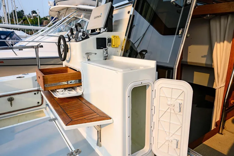  Yacht Photos Pics 2019 Targa 35 boat interior with wooden drawer, steering wheel, and Garmin navigation system.