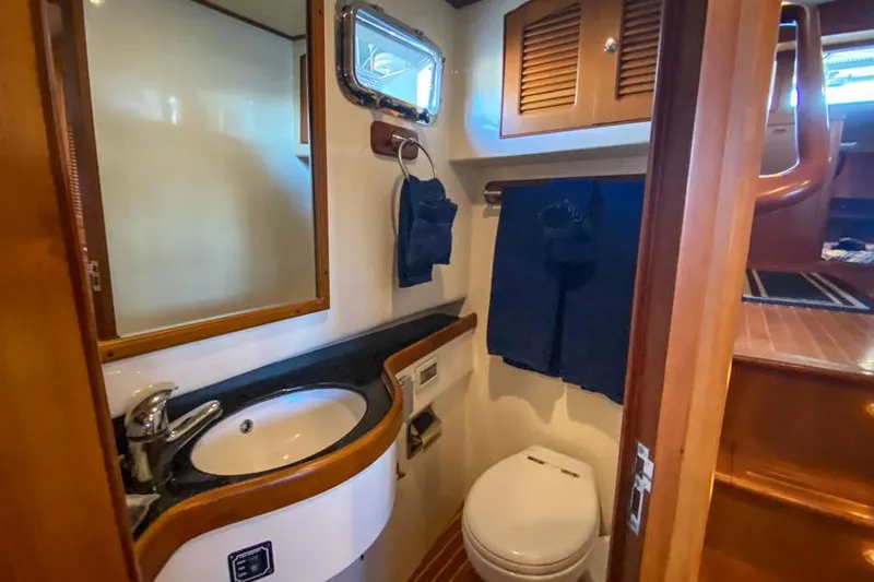 Kairos Yacht Photos Pics Compact bathroom in 2005 Selene 36 yacht with sink, toilet, and wooden accents.
