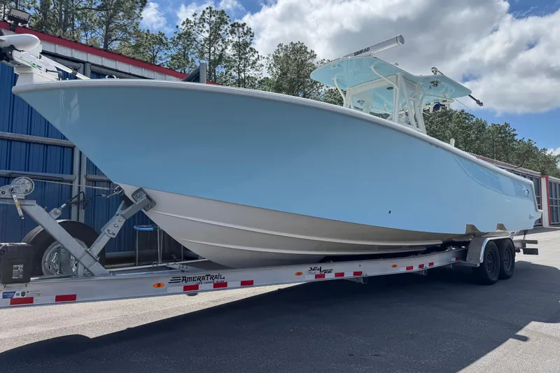  Yacht Photos Pics 2024 SeaVee 32Z boat on trailer, light blue hull, parked outdoors.