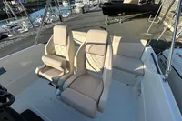 2026 Quicksilver 705 Open boat interior with beige seating at a marina.