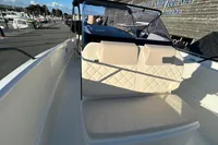 2026 Quicksilver 705 Open boat with beige seating, docked at a marina.