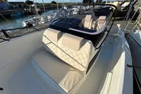 2026 Quicksilver 705 Open boat with beige seating, docked in a marina.