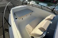 2026 Quicksilver 705 Open boat interior with cushioned seating, dockside view.
