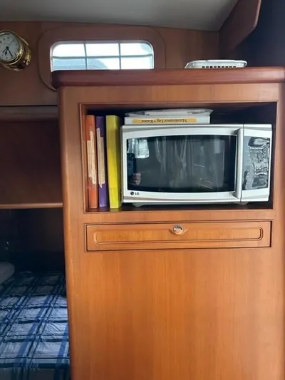 Kairos Yacht Photos Pics Wooden interior of 2005 Selene 36 boat with microwave and books.