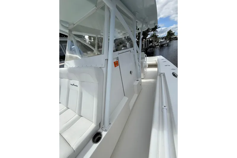  Yacht Photos Pics 2010 SeaHunter 40 boat interior with white seating and clear canopy, docked by a calm waterway.