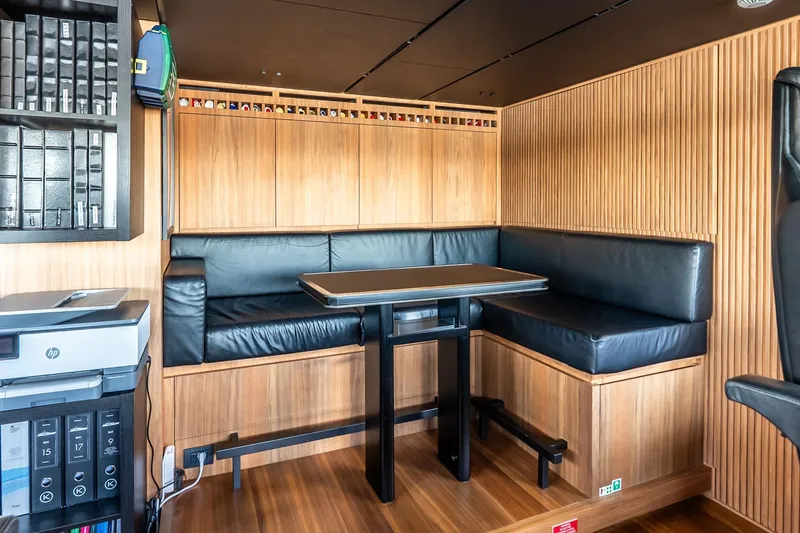 Neverland Yacht Photos Pics Luxurious Sanlorenzo 44 Alloy yacht interior with wood paneling and black leather seating, 2020 model.