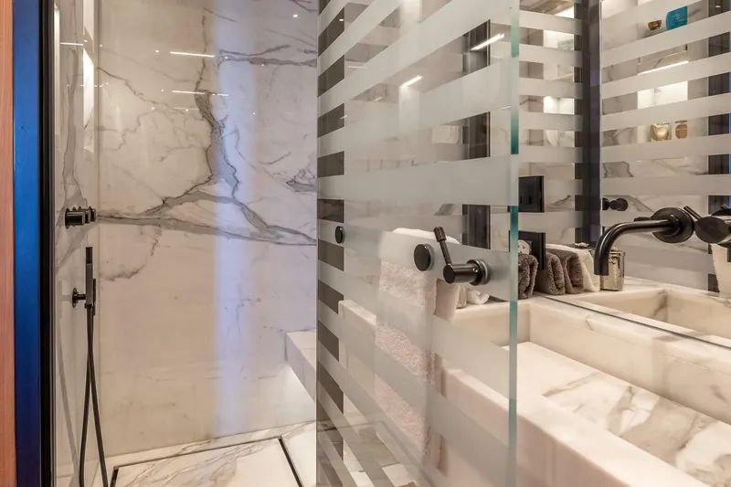 Neverland Yacht Photos Pics Luxurious marble bathroom in 2020 Sanlorenzo 44 Alloy yacht, featuring modern fixtures and frosted glass.
