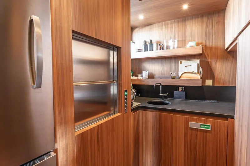 Neverland Yacht Photos Pics Luxurious wooden kitchen interior on 2020 Sanlorenzo 44 Alloy yacht, featuring modern appliances.