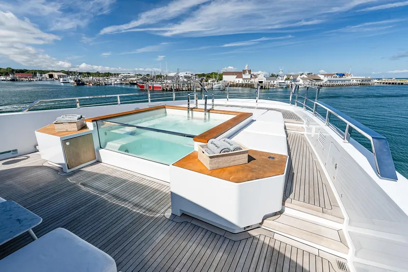 Neverland Yacht Photos Pics Luxurious Sanlorenzo 44 Alloy yacht deck with jacuzzi, overlooking serene marina, 2020 model.