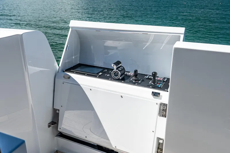 Neverland Yacht Photos Pics Control panel of 2020 Sanlorenzo 44 Alloy yacht with joysticks and screen, overlooking water.