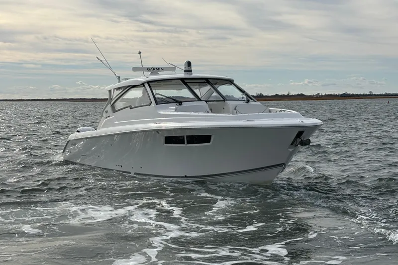  Yacht Photos Pics 2022 Pursuit DC 365 Dual Console boat cruising on open water.
