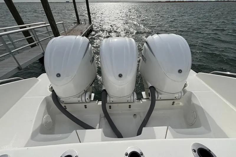  Yacht Photos Pics Triple outboard engines on a 2022 Pursuit DC 365 Dual Console boat by the dock.
