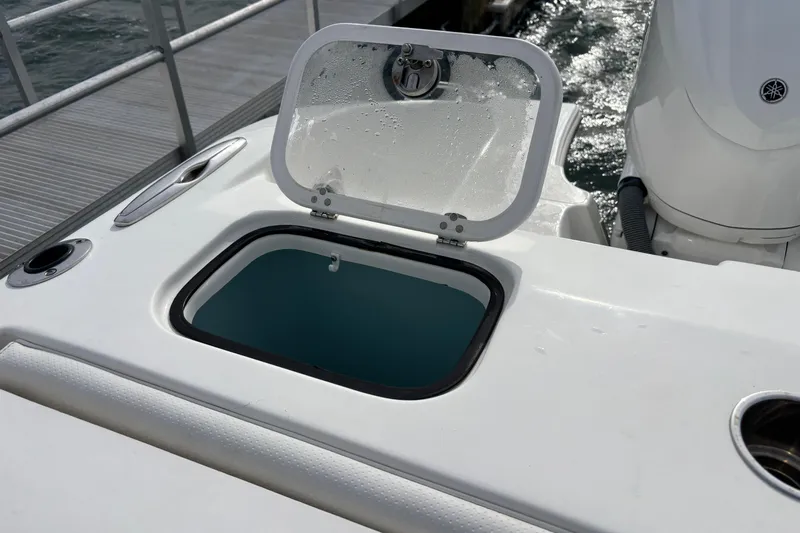  Yacht Photos Pics 2022 Pursuit DC 365 Dual Console boat with open storage compartment near the dock.