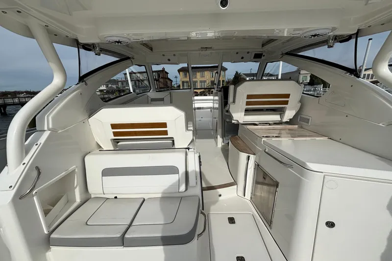  Yacht Photos Pics 2022 Pursuit DC 365 Dual Console interior with seating and storage, docked near waterfront homes.