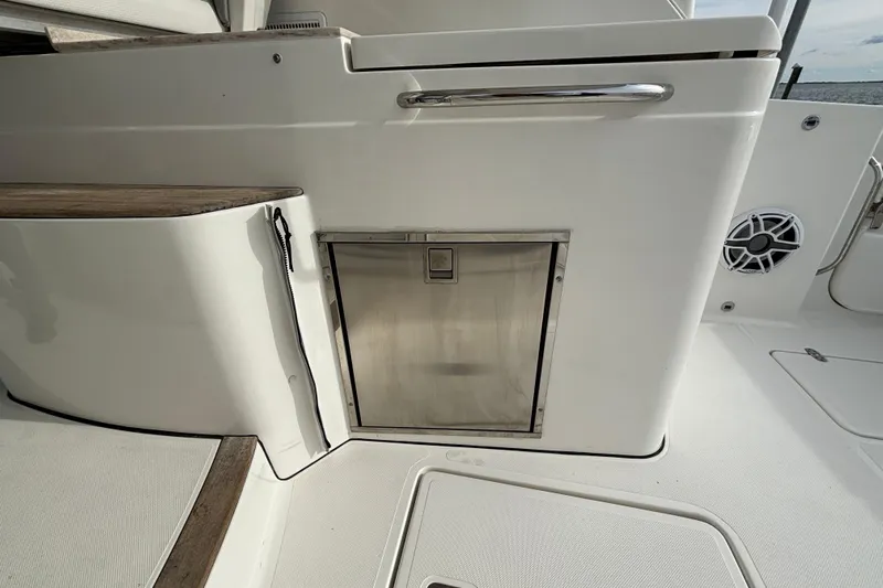  Yacht Photos Pics 2022 Pursuit DC 365 Dual Console interior with stainless steel storage compartment.