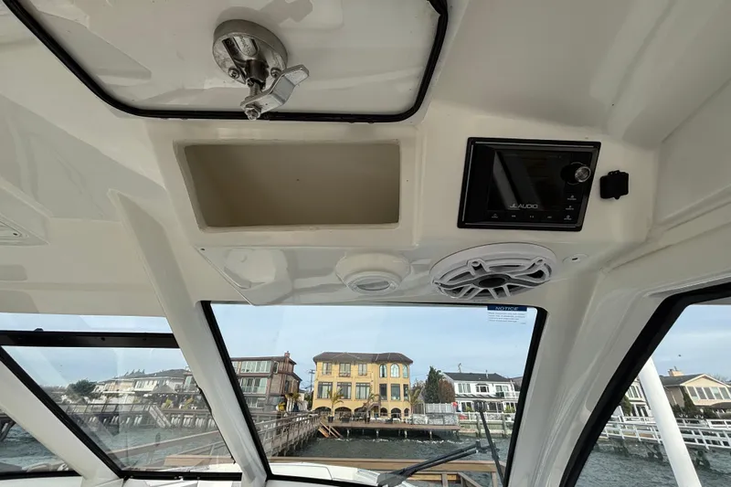  Yacht Photos Pics 2022 Pursuit DC 365 Dual Console boat interior with JL Audio system and waterfront view.