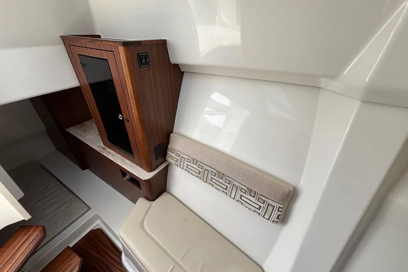  Yacht Photos Pics 2022 Pursuit DC 365 Dual Console interior with wood cabinetry and cushioned seating.
