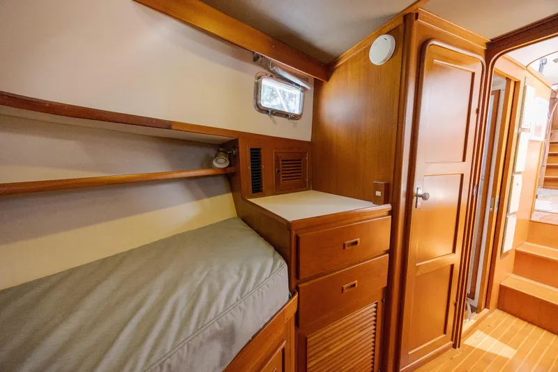  Yacht Photos Pics 1989 Offshore Yachts 48 Yachtfisher cabin interior with wooden cabinetry and cozy sleeping area.