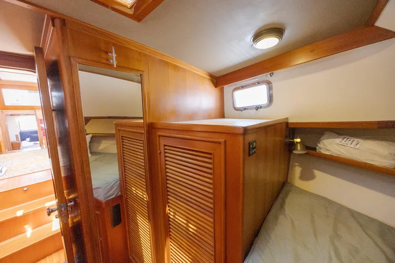  Yacht Photos Pics 1989 Offshore Yachts 48 Yachtfisher cabin interior with wooden finishes and cozy sleeping area.