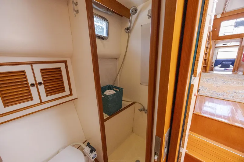  Yacht Photos Pics 1989 Offshore Yachts 48 Yachtfisher bathroom interior with shower and wooden cabinetry.