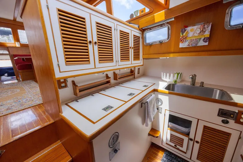  Yacht Photos Pics 1989 Offshore Yachts 48 Yachtfisher kitchen with wooden cabinets and stainless steel sink.