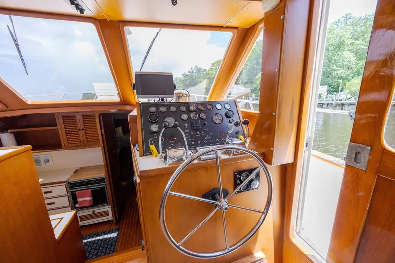  Yacht Photos Pics 1989 Offshore Yachts 48 Yachtfisher helm with wooden interior and navigational instruments.