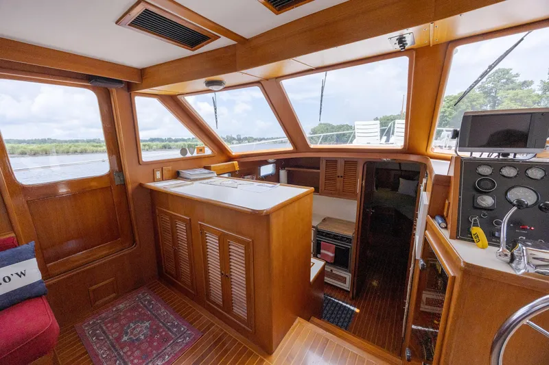 Yacht Photos Pics Interior of 1989 Offshore Yachts 48 Yachtfisher, featuring wood paneling and navigation controls.