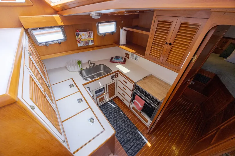  Yacht Photos Pics 1989 Offshore Yachts 48 Yachtfisher galley with wood cabinetry, sink, stove, and ample storage.