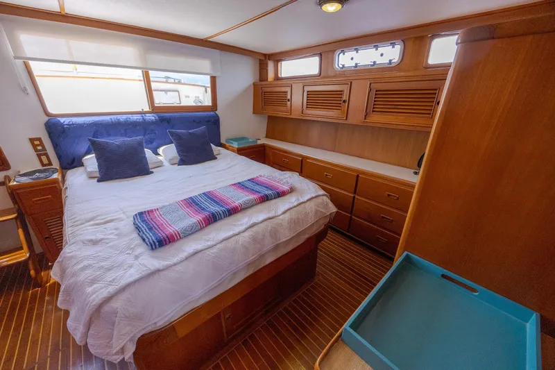  Yacht Photos Pics Luxurious cabin interior of 1989 Offshore Yachts 48 Yachtfisher with cozy bed and wooden furnishings.