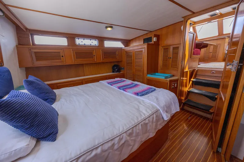  Yacht Photos Pics Cozy cabin interior of 1989 Offshore Yachts 48 Yachtfisher with wood paneling and bedding.