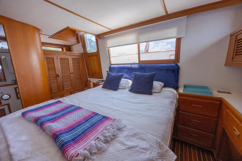  Yacht Photos Pics Luxurious bedroom interior of 1989 Offshore Yachts 48 Yachtfisher with cozy bedding and wooden accents.