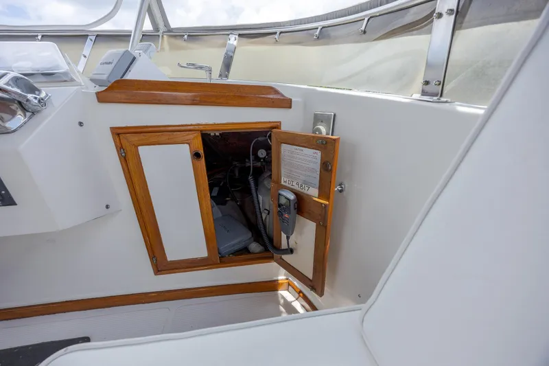  Yacht Photos Pics 1989 Offshore Yachts 48 Yachtfisher interior with open wooden cabinet and control panel.