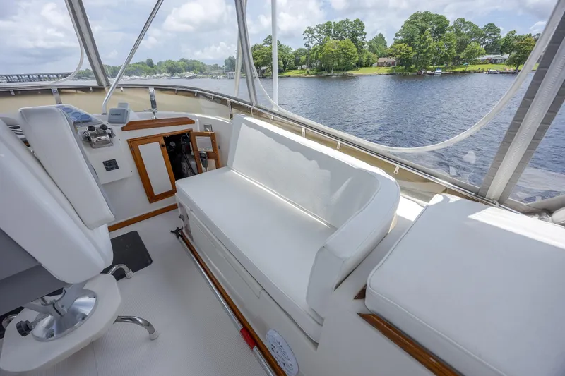  Yacht Photos Pics 1989 Offshore Yachts 48 Yachtfisher interior with white seating and scenic water view.