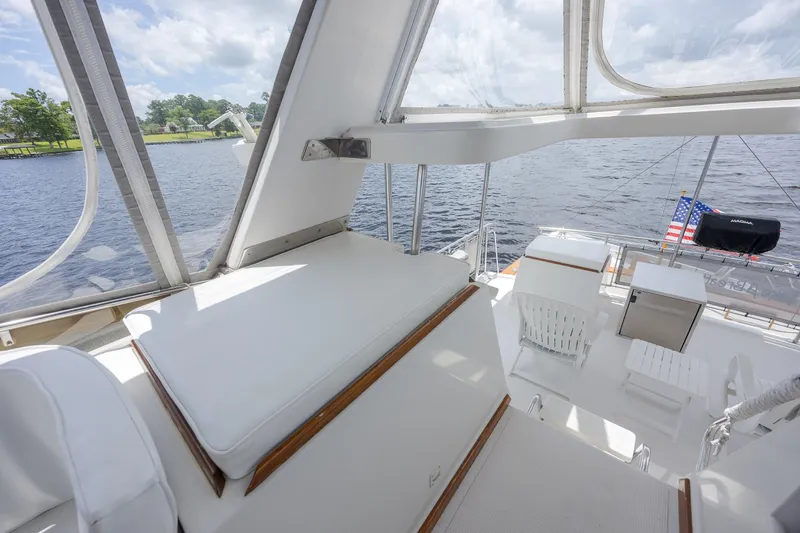  Yacht Photos Pics 1989 Offshore Yachts 48 Yachtfisher interior with seating, water view, and American flag.